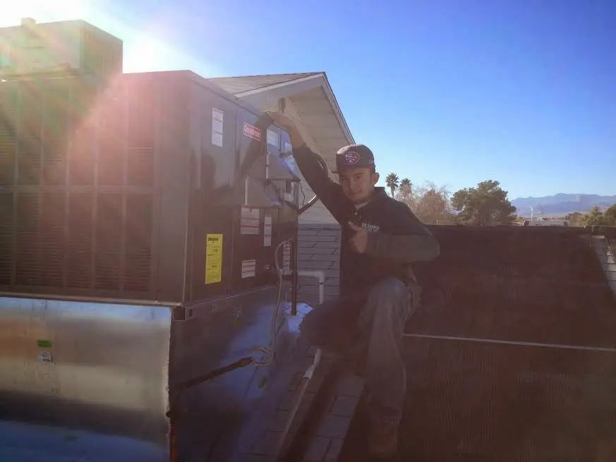 HVAC technician performing AC Tune-Up on a rooftop unit in Metropolis